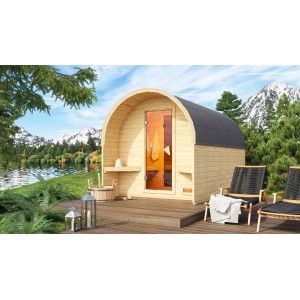 Karibu Fasshaus 3 mit Ofen vor Bergkulisse. Holzfass-Sauna mit Glastür und Außenzubehör.