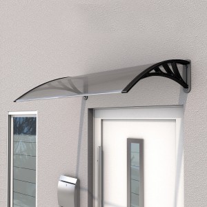 Schwarzes Gutta Pultvordach ECO 120 mit klarer Polycarbonatplatte über einer Haustür.