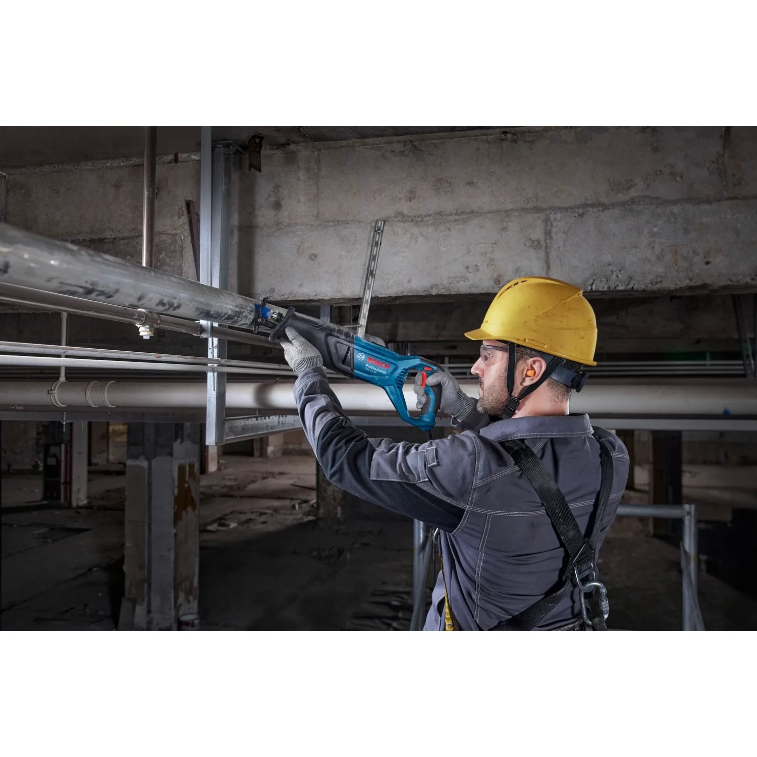 Handwerker sägt Rohr mit Bosch Professional Säbelsäge GSA 12-30 im Koffer.