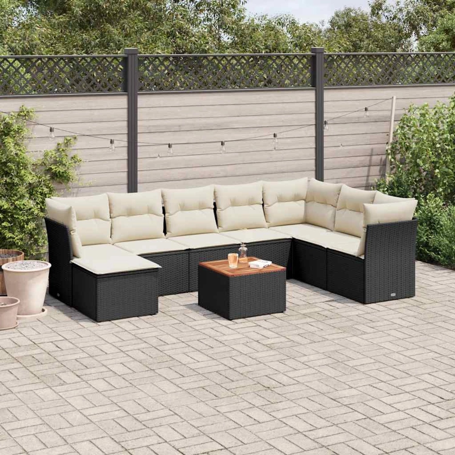 Schwarze 9-tlg. Garten-Sofagarnitur aus Poly Rattan mit cremeweißen Kissen und Tisch.