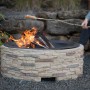 Westmann Feuerstelle in Steinoptik mit Feuer im Garten, Abfanggitter für gemütliche Abende.