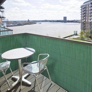 Grüner KARAT PVC Sichtschutzzaun (150x300 cm) auf Balkon mit Tisch und Stühlen.