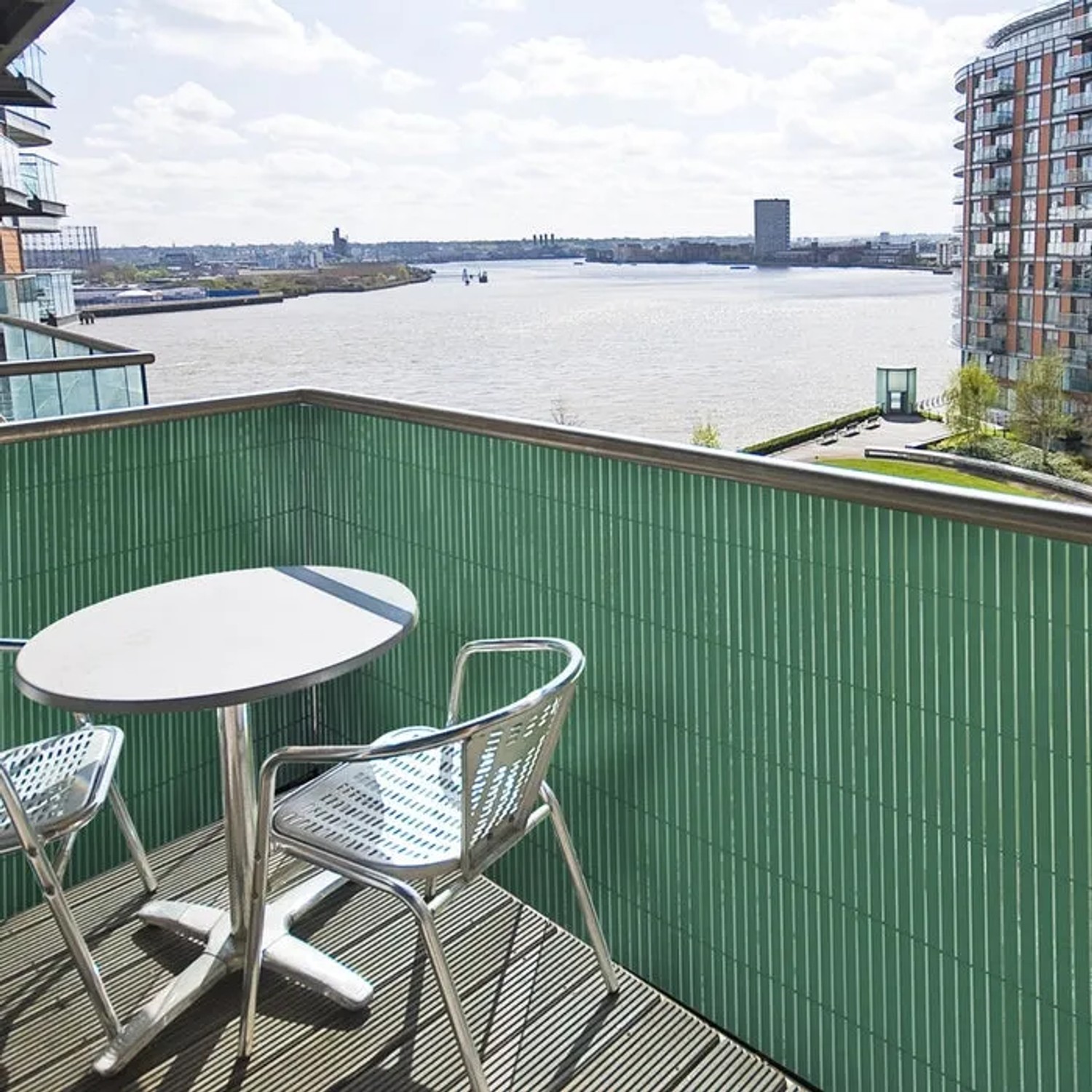 Grüner KARAT PVC Sichtschutzzaun (150x300 cm) auf Balkon mit Tisch und Stühlen.
