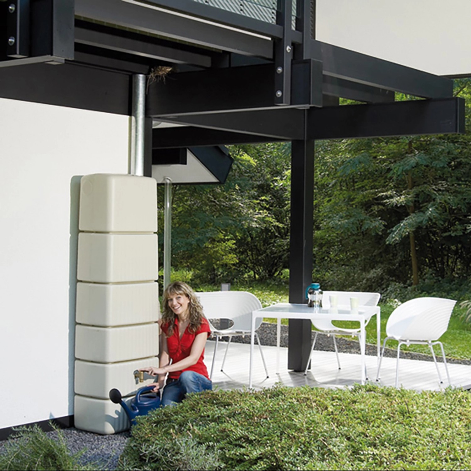 4rain Slim Regenwassertank in Sandbeige mit Zubehör und Frau mit Gießkanne.