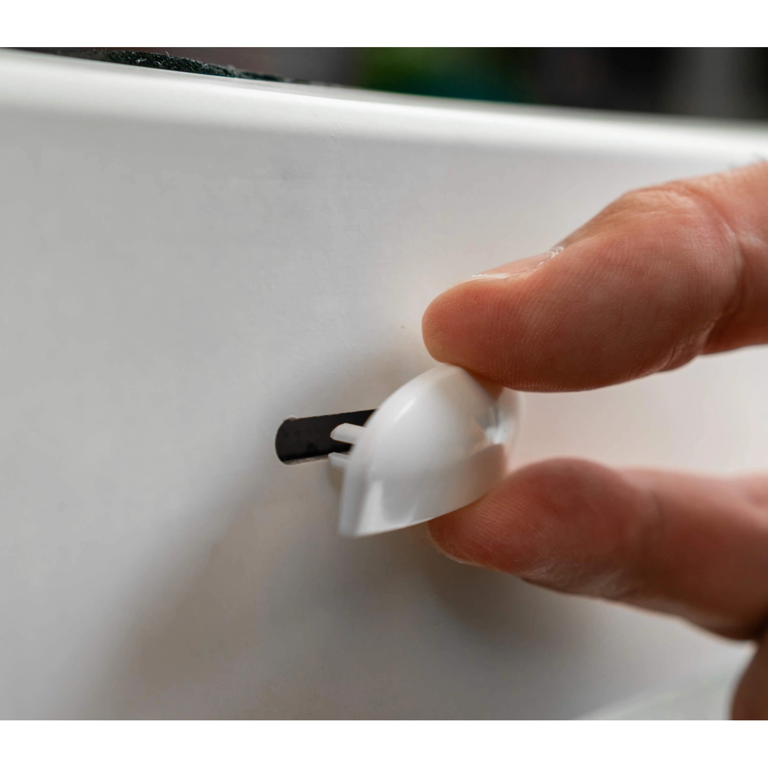 Montage einer weißen Bauheld Wasserschlitzkappe (RAL 9003) am Fenster zur Reduzierung von Zugluft.