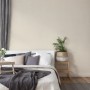 Schlafzimmer mit creme-weißer Vliestapete Uni Matt Strukturiert FSC® an der Wand.