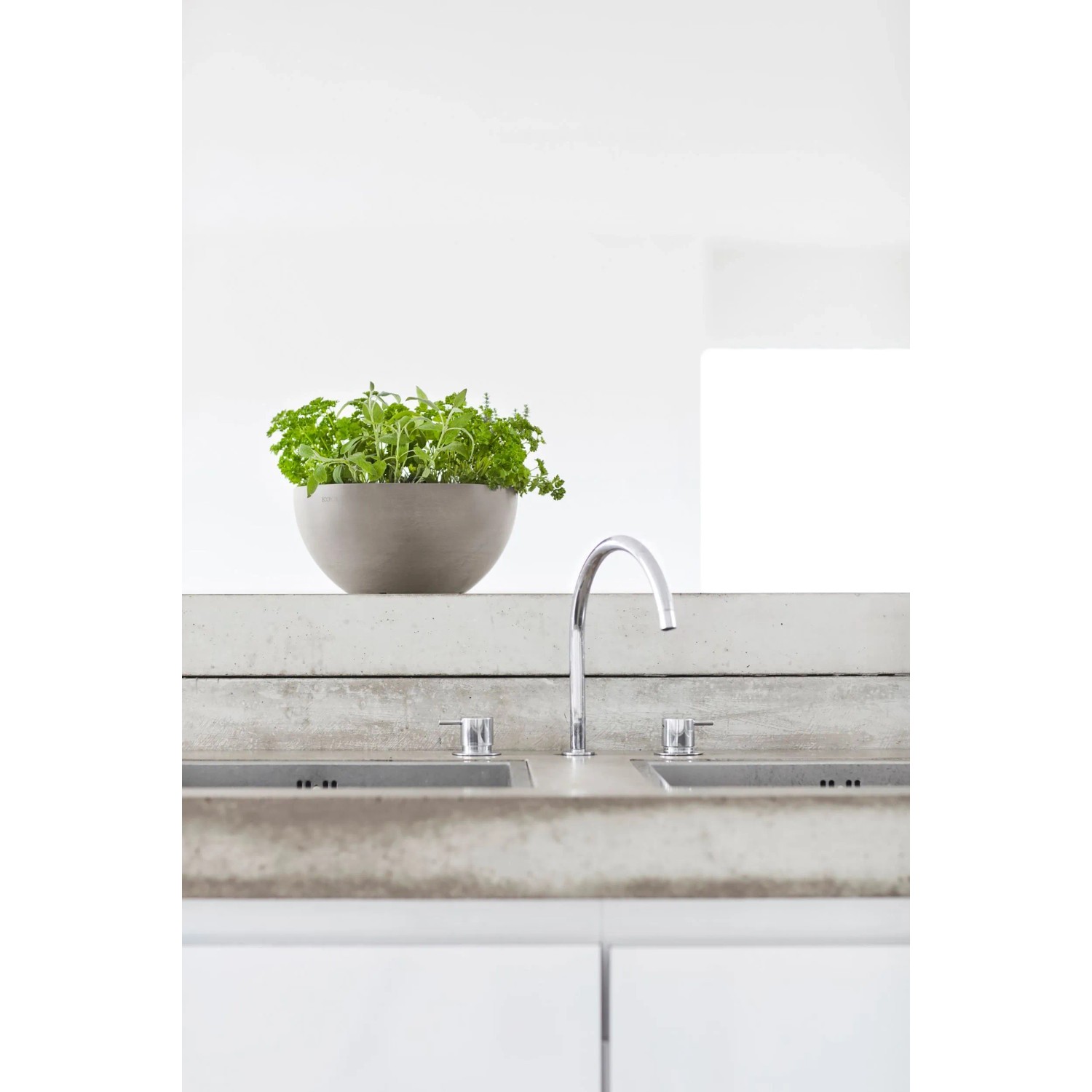Braungrauer Ecopots Pflanztopf Brussels 25 cm mit Pflanze auf Waschbecken.