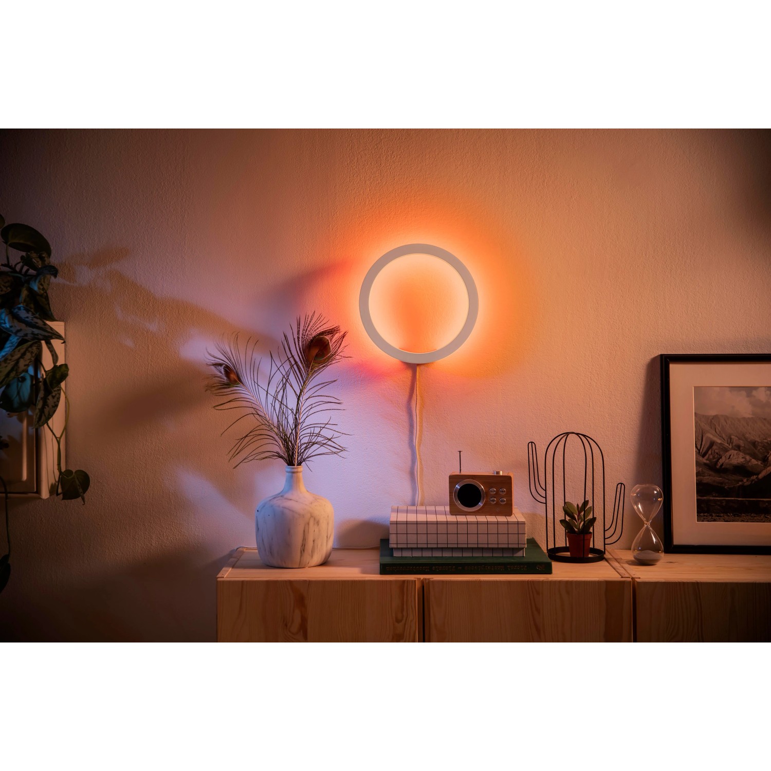Philips Hue Sana Wandleuchte in Weiß mit farbigem Lichteffekt im Wohnraum.