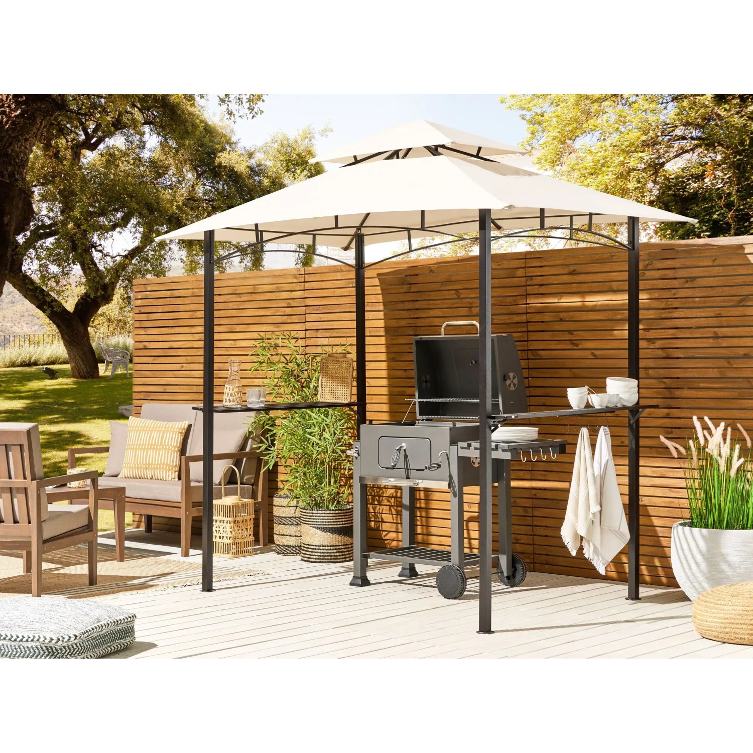 Beiger Pavillon NARO 185x121x245 mit Grillplatz und Ablageflächen im Garten.
