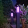 Philips Hue Impress LED-Wegeleuchte, schwarz, mit farbigem Licht im Garten.