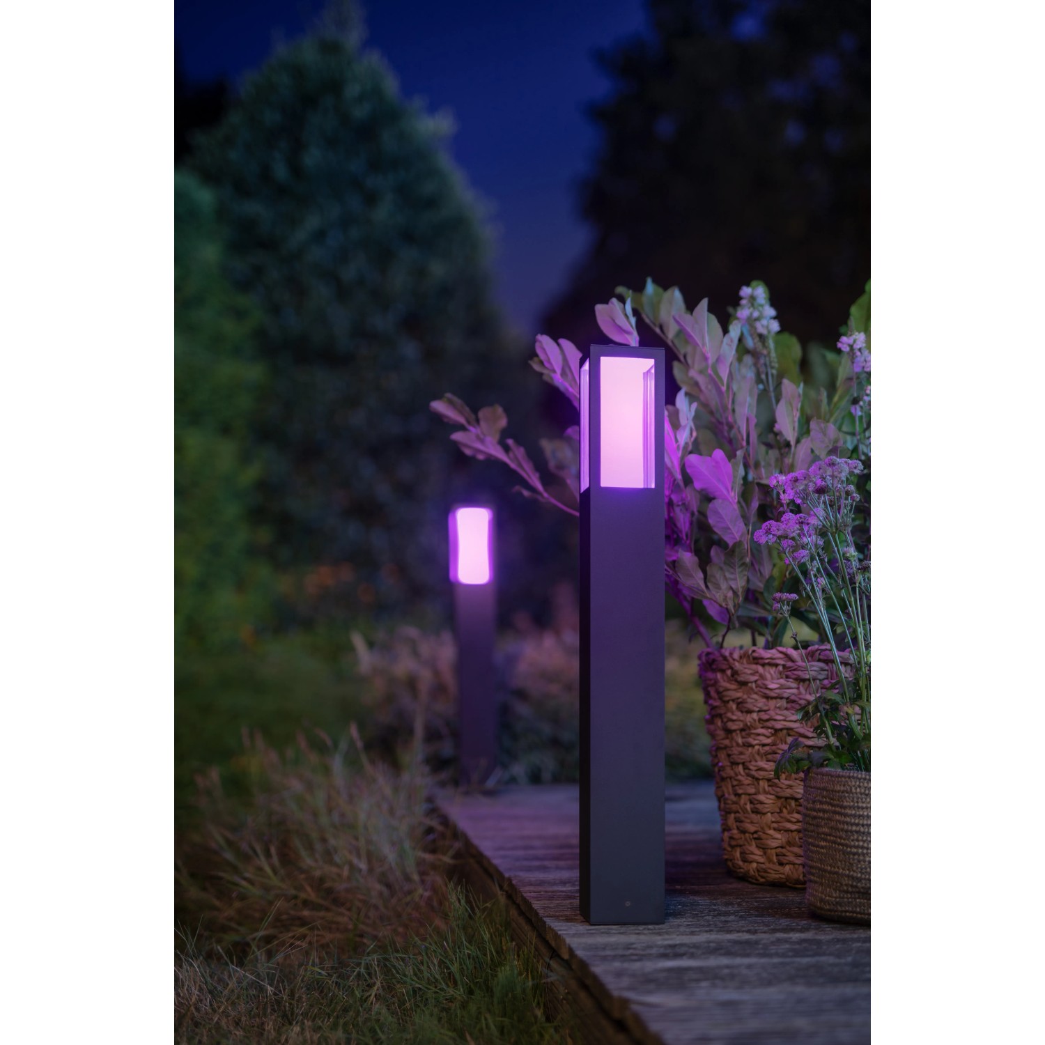 Philips Hue Impress LED-Wegeleuchte, schwarz, mit farbigem Licht im Garten.