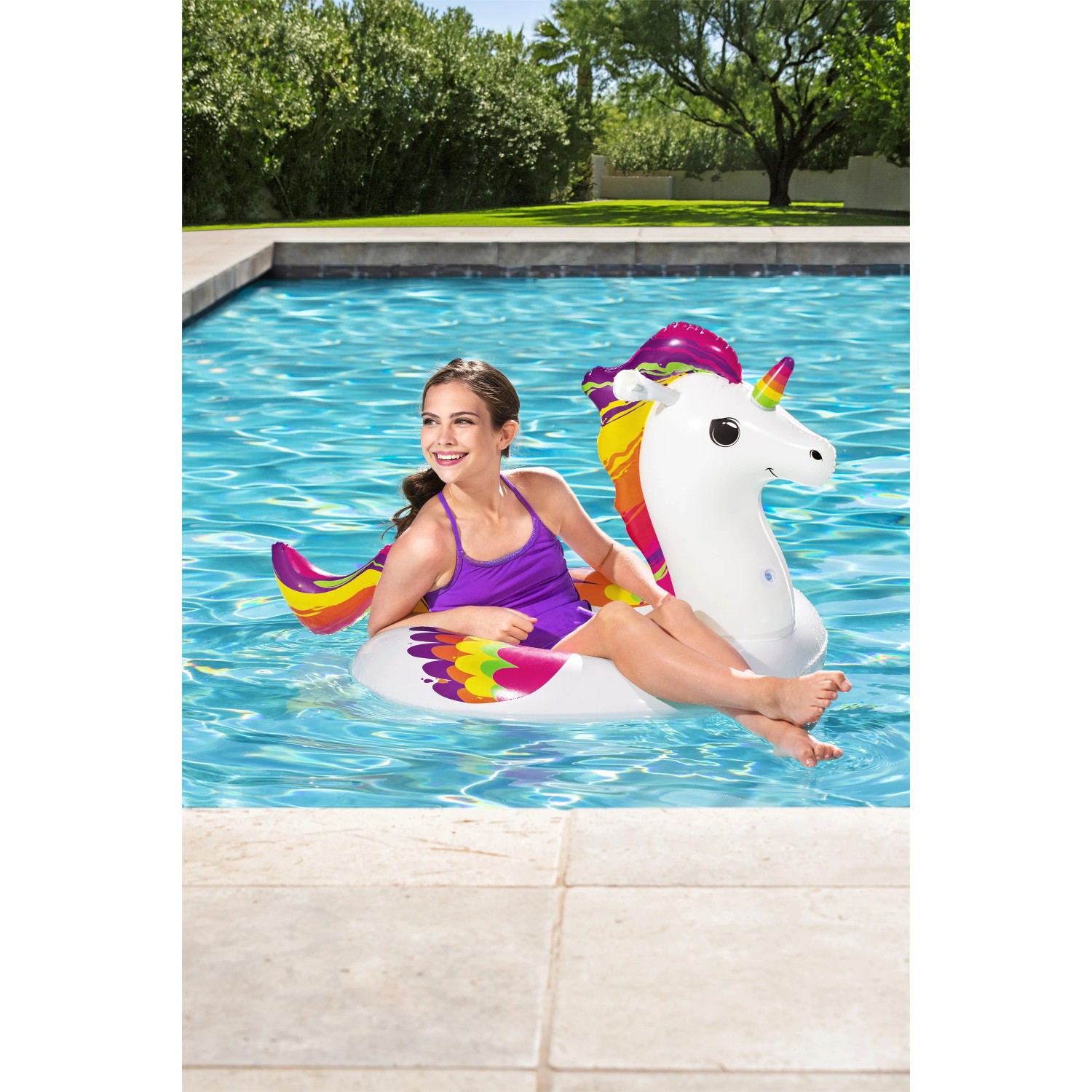 Mädchen auf Bestway Schwimmring Einhorn im Pool. Buntes Design, ideal für Wasserspaß.