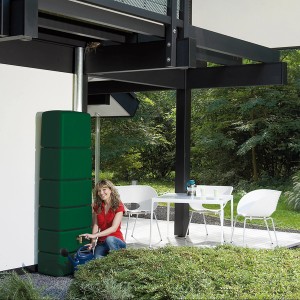 4rain Regenwassertank Slim 650 l grün mit Frau beim Wasserzapfen.