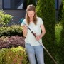 Frau montiert Gardena combisystem-Kleinhäckchen mit 3 Zinken an einen Stiel im Garten.