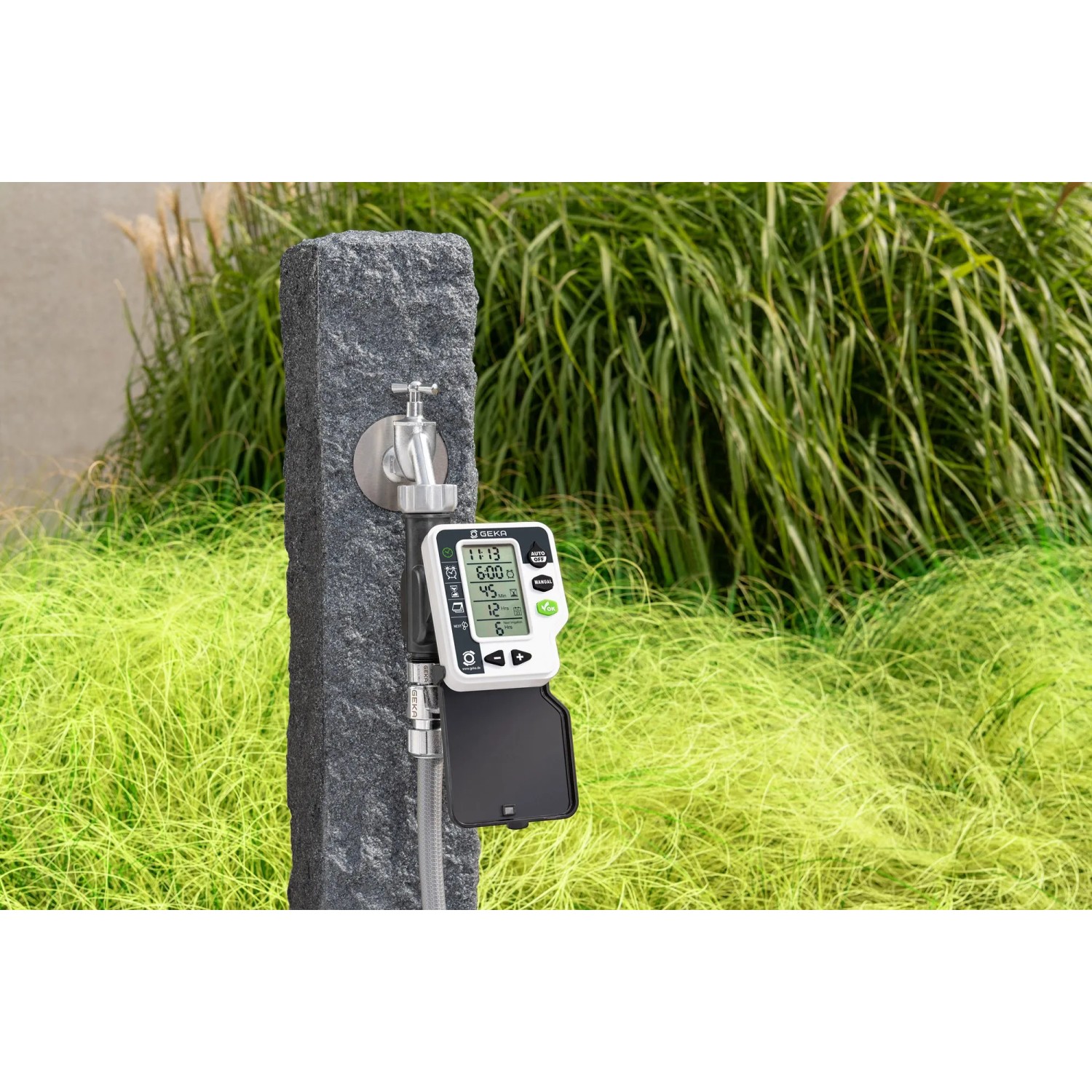 Geka Bewässerungscomputer mit Hahnadapter an Wasserhahn im Garten.