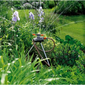 GARDENA Classic Kreisregner Samba im Einsatz, bewässert Gartenfläche. Regner mit Dreibein-Stativ.