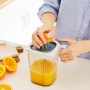 Rotho Messbecher Loft: Frau presst Orange mit Zitruspresse Aufsatz. Küchenhelfer transparent/blau.