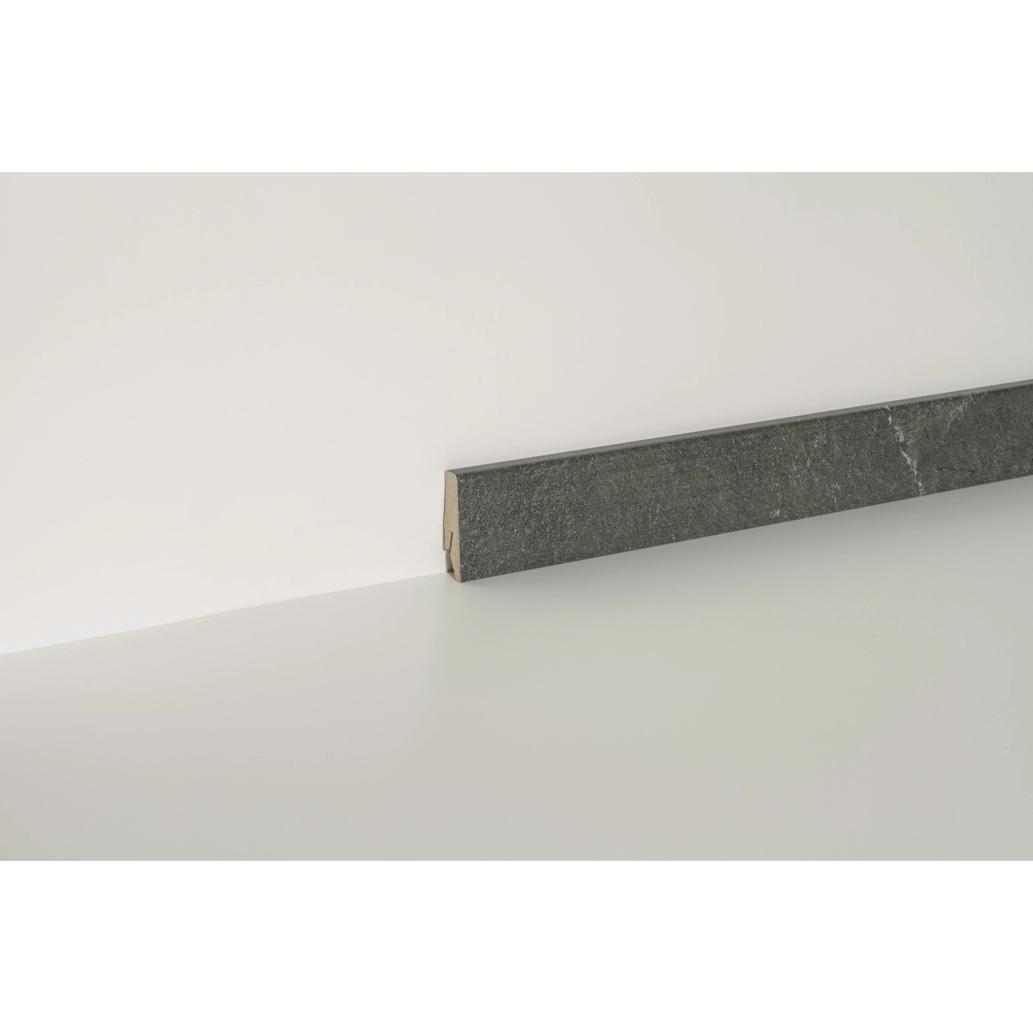 Sockelleiste Neo 2.0 Mineralveined Slate, 2400 mm lang, an weißer Wand befestigt.