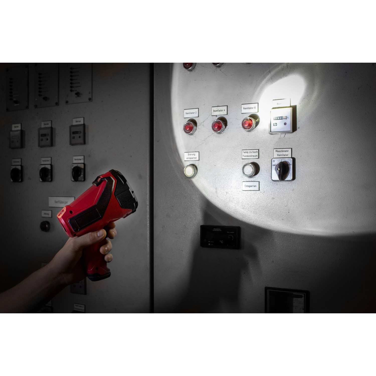 Eufab LED Handscheinwerfer 3W in Rot/Schwarz leuchtet Schaltschrank aus, gehalten von Hand.