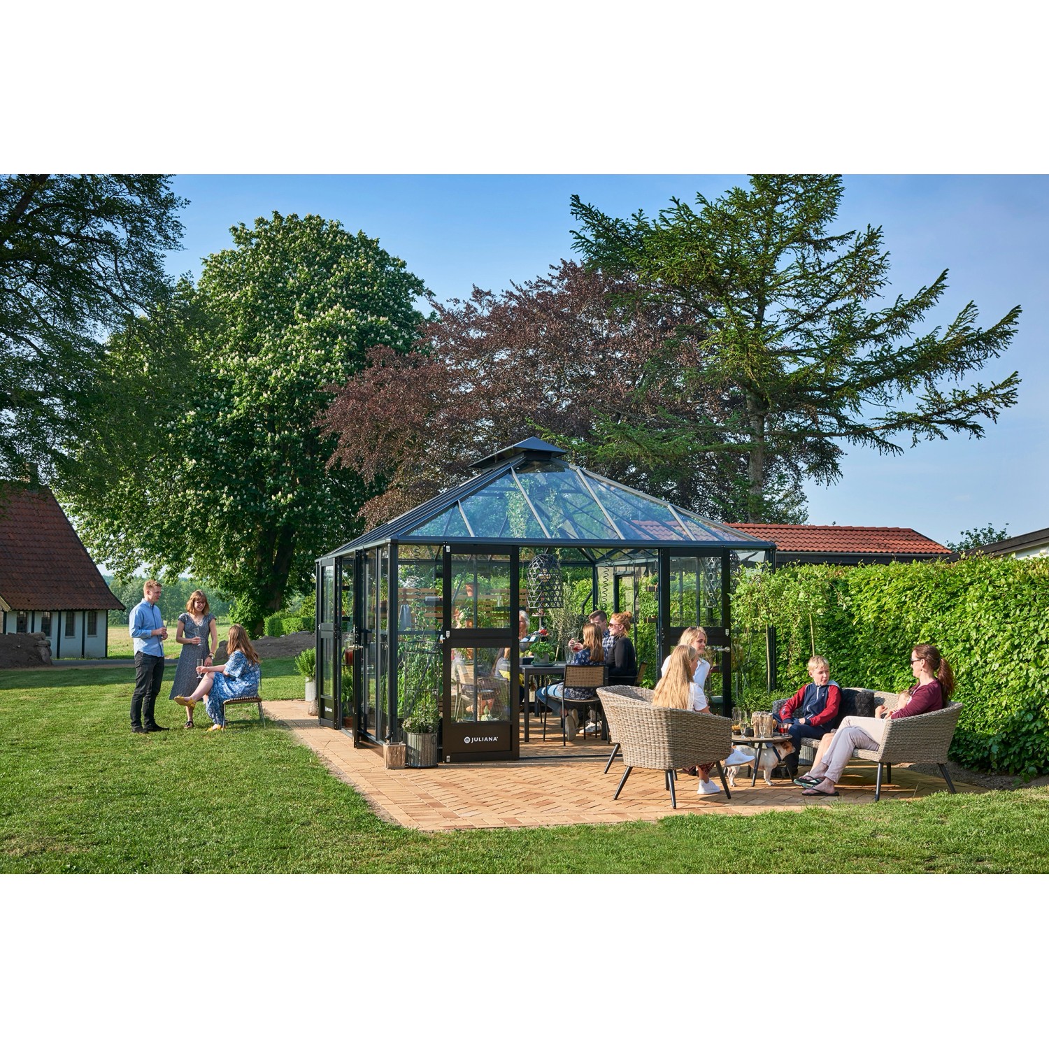 Juliana Gewächshaus Grand Oase 18 in Anthrazit-Schwarz mit Personen im Garten.
