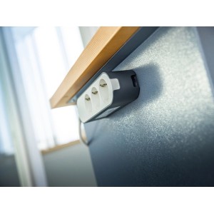 LUX-TOOLS PRO Nano Tape befestigt eine Steckdosenleiste unsichtbar unter einem Holzregal. Transparentes, doppelseitiges Klebeband.