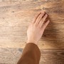 Egger DecoWall Wandpaneel Namur Fichte Natur mit Hand, Holzstruktur gut sichtbar.