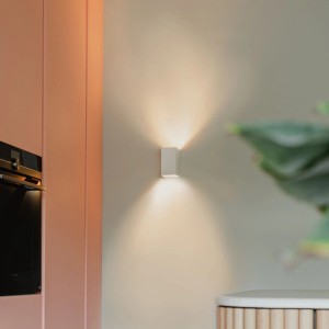Weiße, quadratische QAZQA Design Wandleuchte Sabbir an einer Wand mit Lichteffekt.