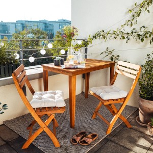 3-teiliges Balkonmöbel-Set Grenora aus FSC-Holz in Natur mit Tisch und zwei Stühlen mit Auflagen.