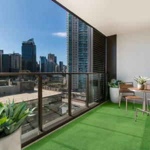 Balkon mit grünem Primaflor Rasenteppich Comfort und Stadtblick.