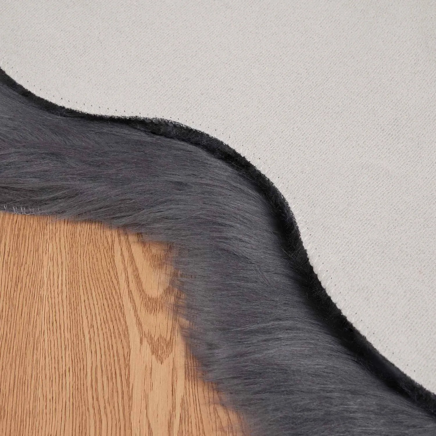 Detailaufnahme: Anthrazitfarbener vidaXL Kunstfell Teppich (80x120 cm) auf Holzboden.