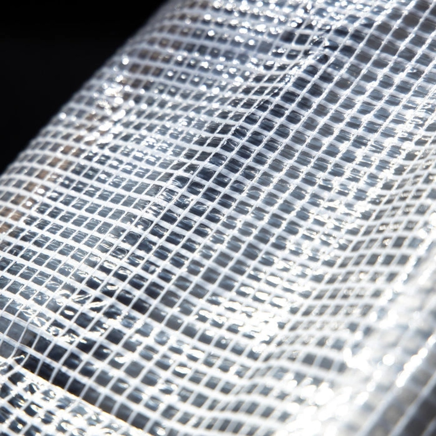 Detailaufnahme: Weiße, wasserdichte KARAT Abdeckplane Leno Extra (240 g/m²) mit Gitternetz.