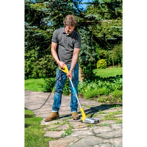 Mann benutzt Gloria Thermoflamm Bio Fix Unkrautbrenner auf Steinweg im Garten.