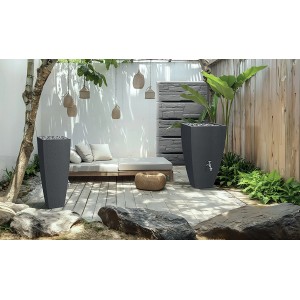 Graue Waterform Regentonne Wall Stone 400 l im Garten mit Steindekor und Wasserhahn.