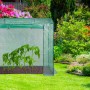 Grünes Relaxdays Tomatengewächshaus aus Polyethylen mit jungen Pflanzen im Garten zur Anzucht.