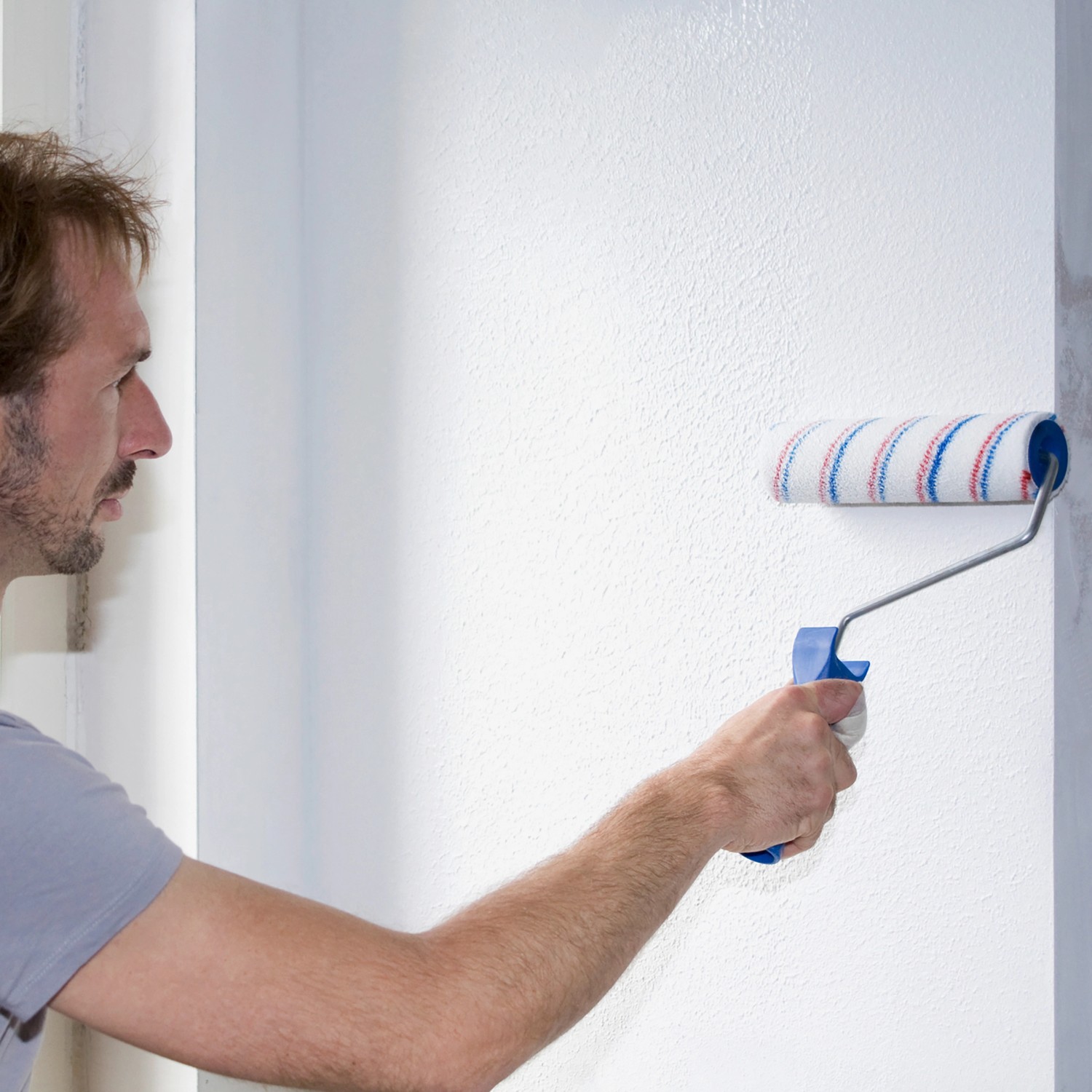 Mann streicht Wand mit Knauf Easy Putz Schneeweiß. Fertigputz mit feiner Körnung.