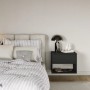 Schwarzer Selsey Nachttisch Framme, wandhängend, mit Schublade und offenem Fach, neben einem Bett. Modernes Schlafzimmerdesign.