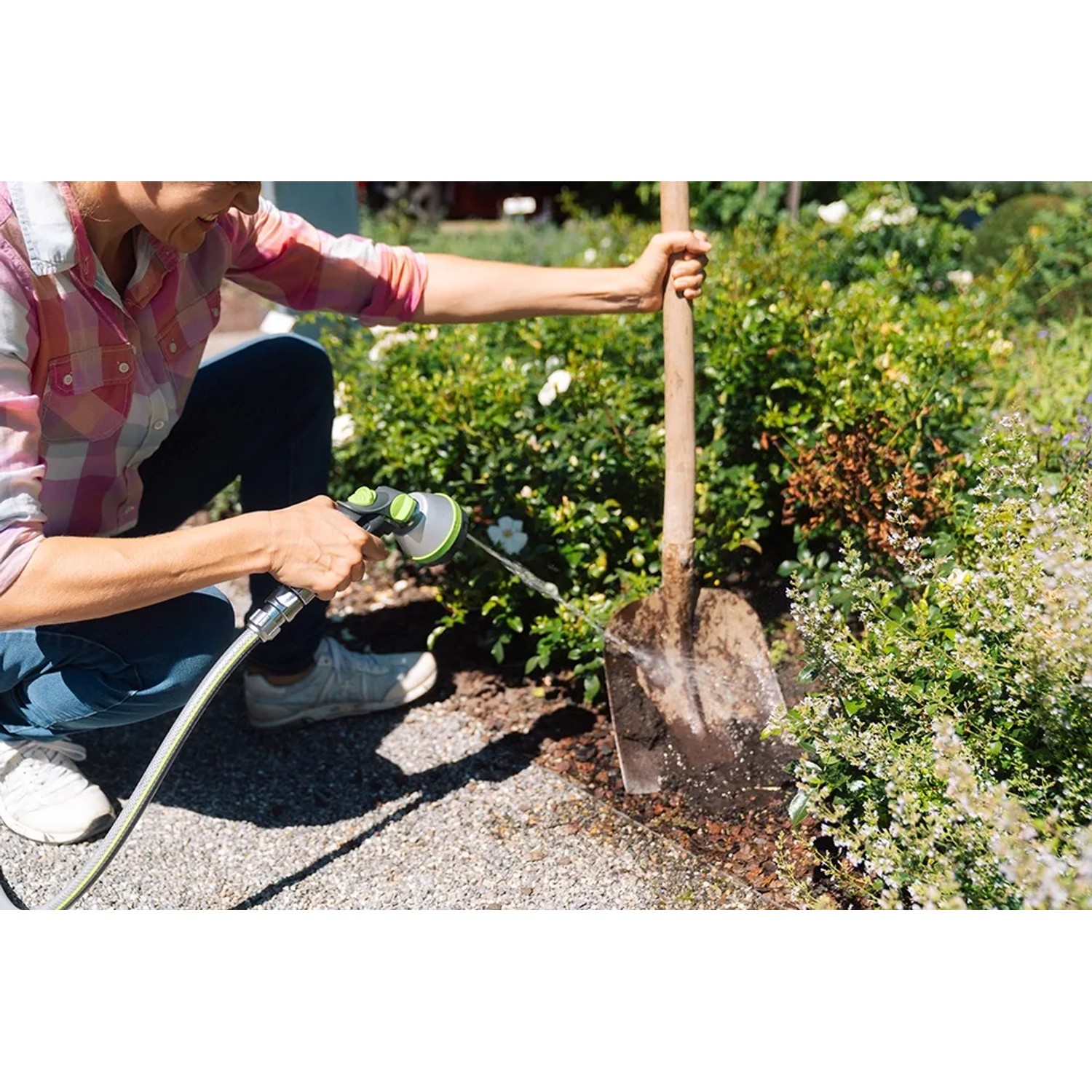 Frau bewässert Garten mit Geka Multibrause Plus 5S Grau. Gartenspritze mit 5 Strahlarten.