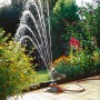 Gardena Comfort Regner Tango bewässert Garten mit Blumen. Teil- und Vollkreisregner.