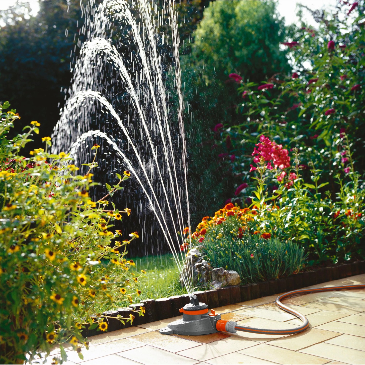 Gardena Comfort Regner Tango bewässert Garten mit Blumen. Teil- und Vollkreisregner.