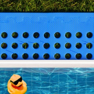 Blaue eyepower Poolmatte 62x62 cm auf Rasen neben Pool, schützt den Untergrund und bietet Rutschschutz.