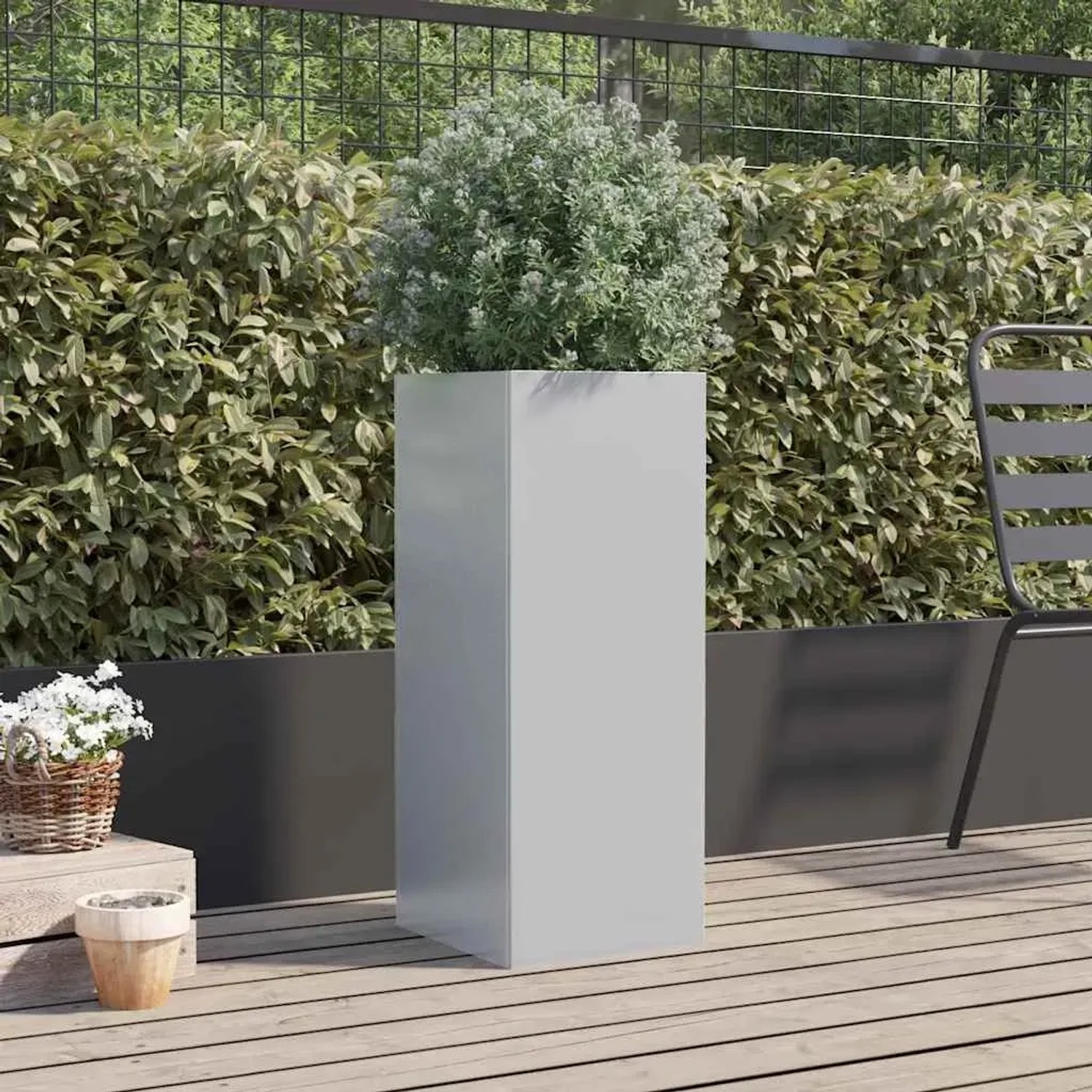 Hoher, silberner Pflanzkübel aus verzinktem Stahl mit Pflanze auf Holzterrasse. Ideal für Garten und Balkon.