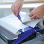 LUX Kleistergerät mit Rollenhalterung im Einsatz: Tapete wird zugeschnitten.