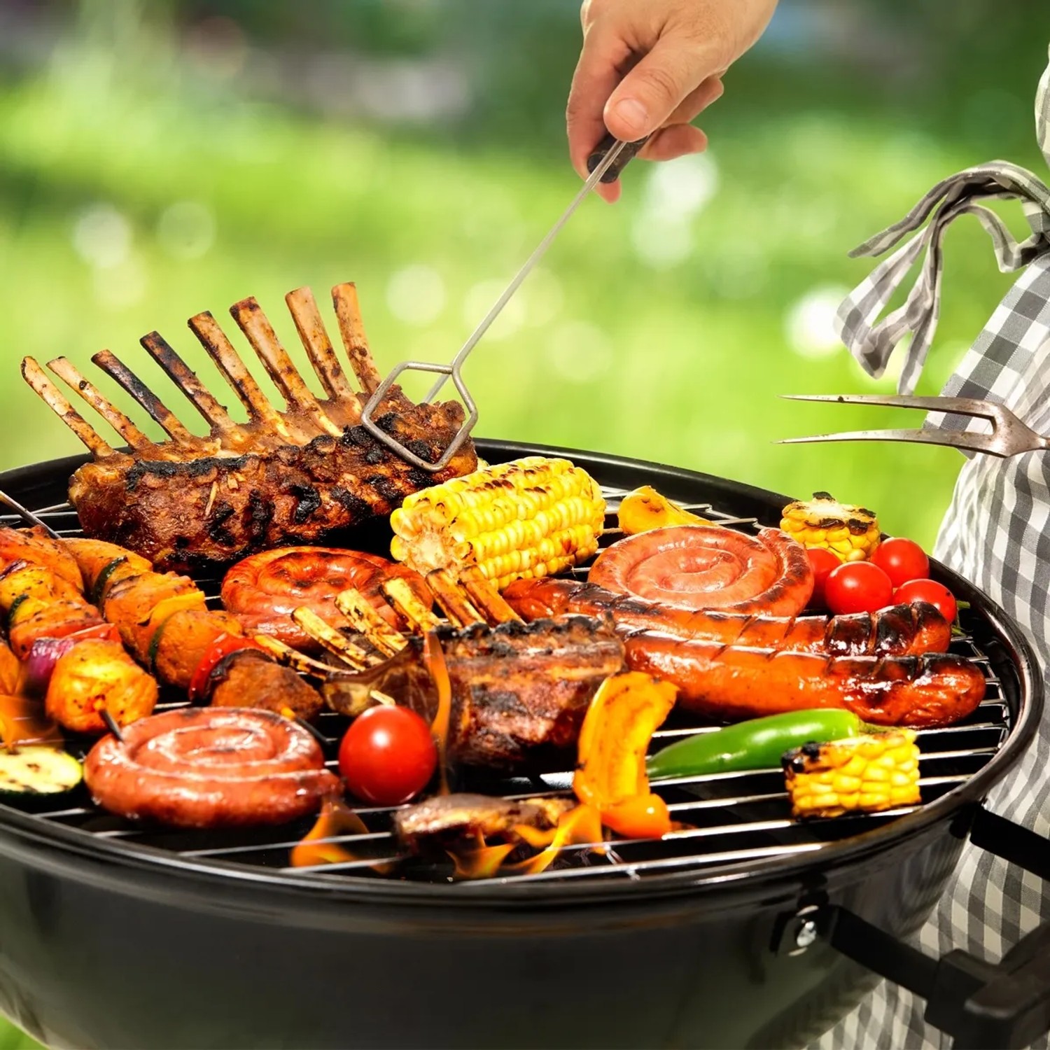 Edelstahl Grillrost (44,5 cm) mit Grillgut wie Fleisch, Gemüse und Maiskolben.