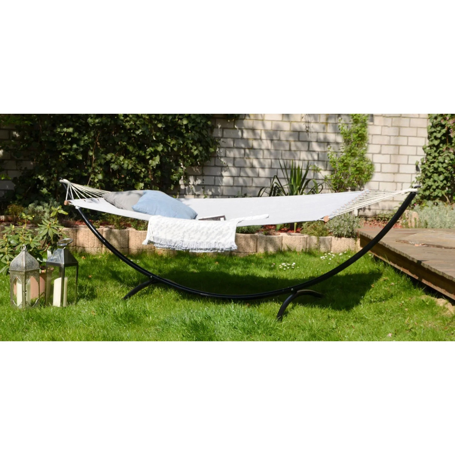 AMANKA XXL Stabhängematte Lilac Grau auf schwarzem Gestell im Garten mit Kissen und Decke.