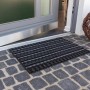Anthrazitfarbene Astra Fußmatte Poly Brush 40x60 cm vor einer Haustür.