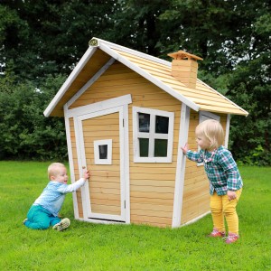 Axi Alice Spielhaus aus Holz in Braun und Weiß mit zwei spielenden Kindern im Garten.