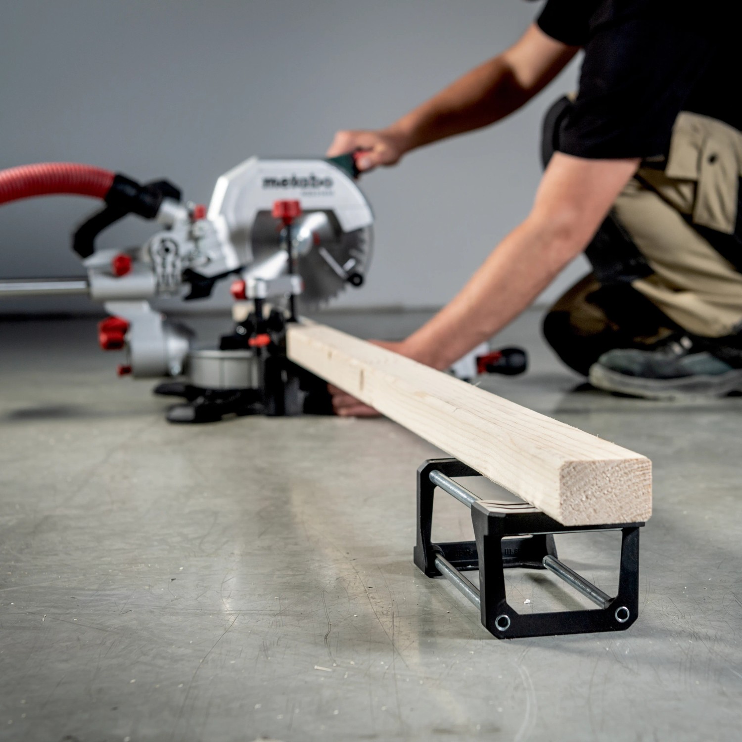 Metabo Kapp- & Zugsäge KGS 254 M beim Sägen eines Holzstücks. Inkl. 2 Sägeblätter.