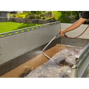 Gardena Reinigungs-Grundausstattung im Einsatz: Schlauch mit Spritze reinigt eine Ladefläche.