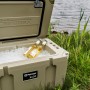Geöffnete Petromax Kühlbox Sand 50l mit Eis und Getränken vor einem See. Ideal für Camping.