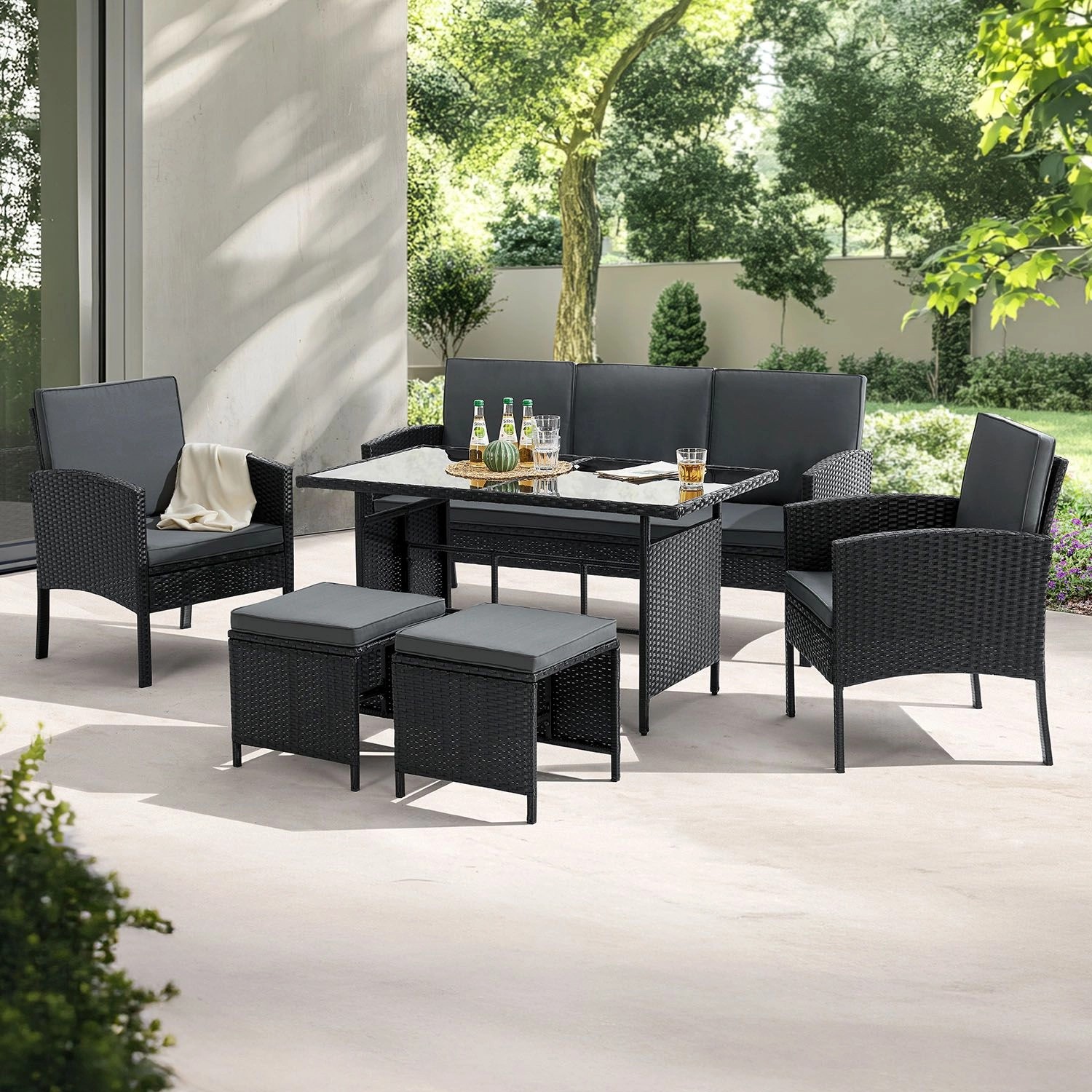 Schwarze Juskys Polyrattan Gartenmöbel Sitzgruppe Turin mit Tisch, Bank, Stühlen und Hockern.